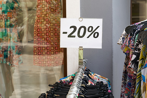 Notice of a 20 percent discount on clothing at a store in the old town of Riva del Garda in Italy