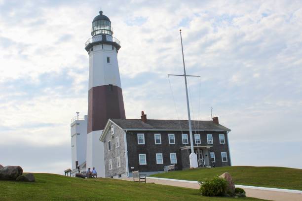 istock a white and red lighthouse sitting next to a green grass field 1690958173