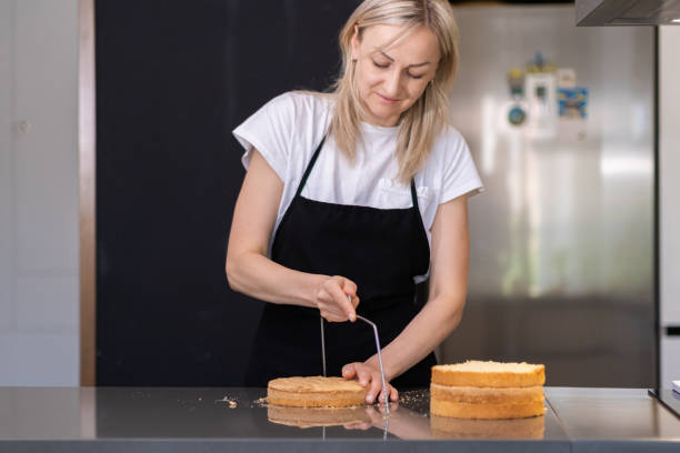 istock Focused blonde housewife showing tutorial of cutting baked cake with string knife 1690958369