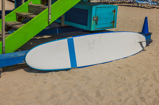 View of surfboard lying near water guard station on Miami Beach. Water sports equipment. USA.