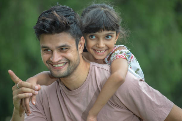 istock Father piggybacking smiling daughter in park 1690961620
