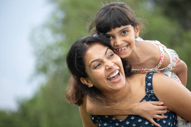 istock Mother piggybacking smiling daughter in park 1690961752