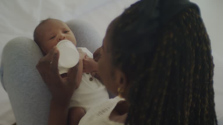 Mother giving milk to her little newborn baby