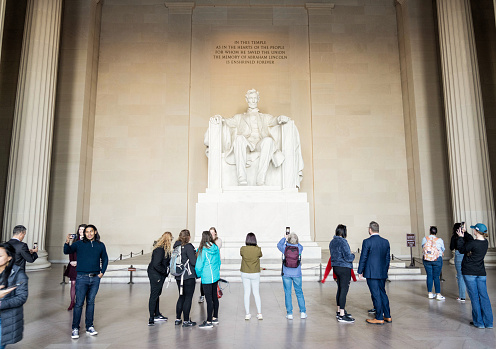 Washington DC, USA - People taking photos of the marble statue of the 16th US President Abraham Lincoln, housed within the Lincoln Memorial building.