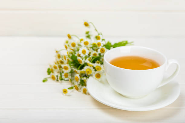 istock Chamomile tea in cup on  texture background. Natural hour with chamomile flowers. Herbal tea. Immunity tea.Natural healer concept. Healthy detox drink.Close up. Place for text. 1690973845