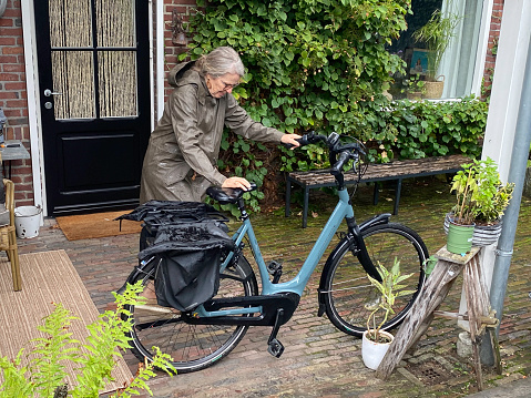 Woman coming home on her electric bicycle on a rainy day