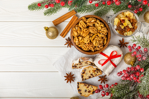 Christmas stollen on wooden background. Traditional Christmas festive pastry dessert. Holiday concept. Dessert, cake, pie with marzipan, nuts and dried fruits. Stollen for Christmas. Spicy pastries.