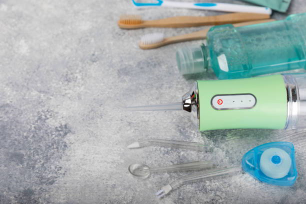 istock Electronic oral irrigator, toothbrush, paste, dental floss and mouthwash on marble background. Dental tool for oral hygiene. Electric Interdental Cleaner. Dental water shower. Oral care concept. 1690984010