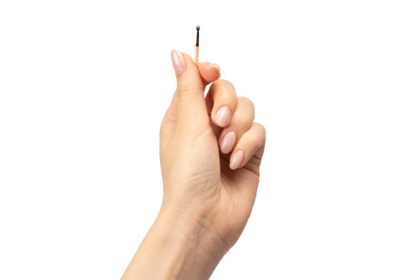istock Lit match in a woman hand isolated on a white background. 1690984034