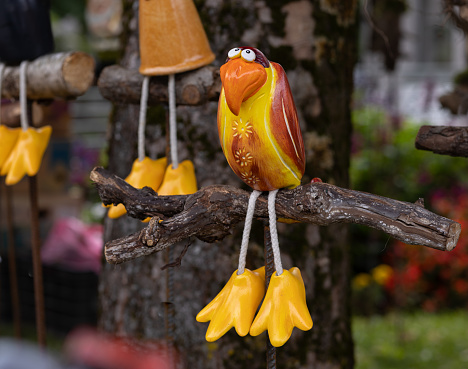 Bright yellow toy ceramic bird with big paws for sale in street market. High quality photo
