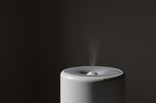 Diffuser, air purifier or humidifier releases strong stream of cold steam with essential oil at room. Aroma oil steam aromatherapy. Body health treatment. Spa and wellness.
