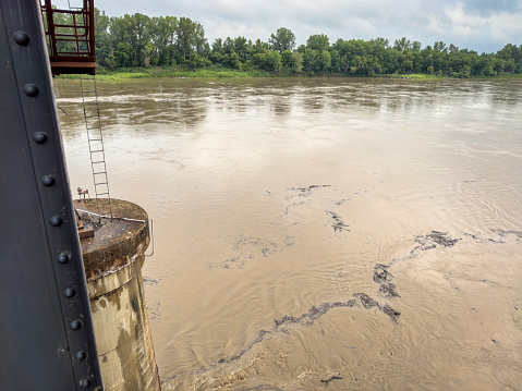 debris floating on the rising Missouri River seen from an old railroad bridge in Boonville, MO