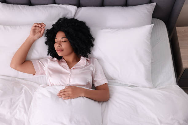 istock Beautiful young woman sleeping in soft bed, above view 1691017153