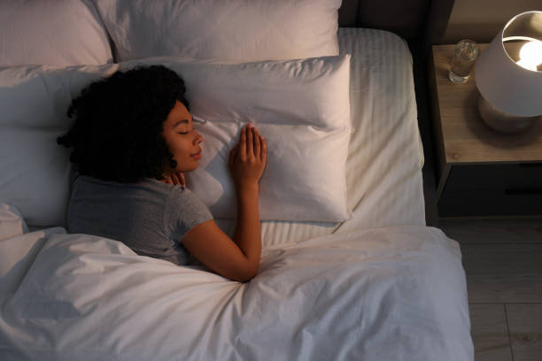 istock Young woman sleeping in soft bed at night, top view 1691017696
