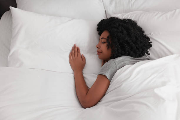 istock Beautiful young woman sleeping in soft bed, top view 1691017707