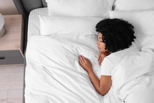 istock Beautiful young woman sleeping in soft bed at home, top view 1691018284