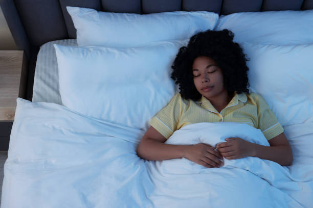istock Young woman sleeping in soft bed at night, above view 1691018298