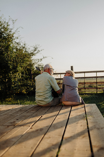 Senior couple resting on patio and watching sunset