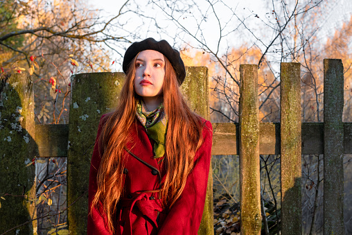 A young woman in a red coat in the autumn forest.