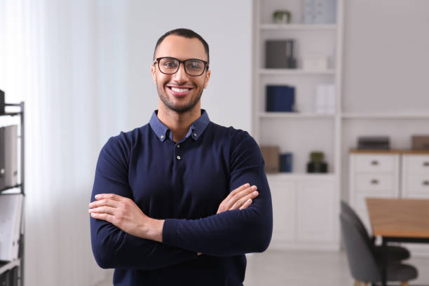 istock Smiling young businessman with eyeglasses in modern office. Space for text 1691033699
