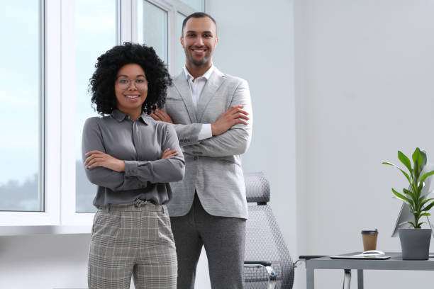 istock Young smiling colleagues near window in modern office 1691034231