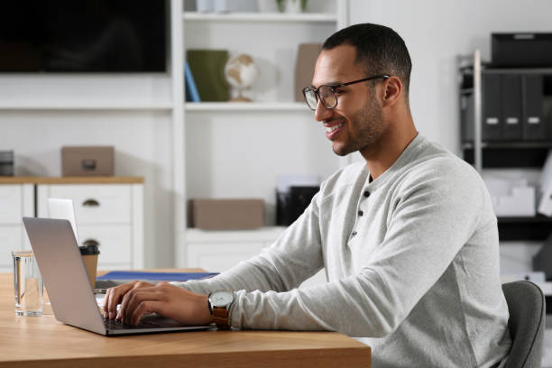 istock Young man working on laptop at table in office 1691034239