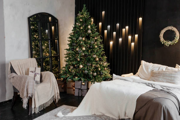 interior del dormitorio decorado para las vacaciones de navidad. interior de la casa con un árbol de navidad sobre un fondo de pared oscuro. - pillow southwest usa bedroom ornate fotografías e imágenes de stock