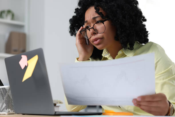 istock Deadline concept. Stressed woman holding document and looking at laptop in office 1691035982