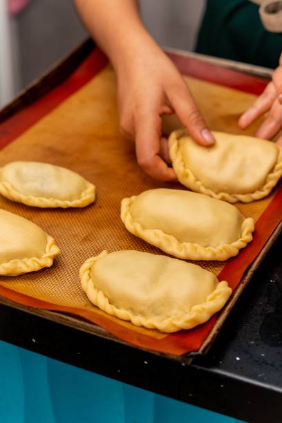 istock a woman making empanadis that have been made from uncooked dough 1691038303