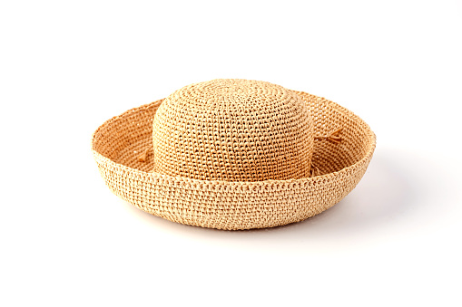 Beautiful straw hat, beautiful with a ribbon and bow on the beach hat, white background.Concept of fashion clothing accessories and beach holidays.Texture of summer straw hat from interwoven raffia.