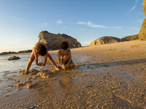 istock Two boys are playing in the sand at the beach 1691040614