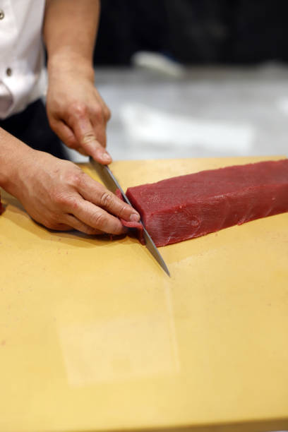 шеф-повар разделывает красного тунца для суши - tuna tuna steak raw bluefin tuna стоковые фото и изображения