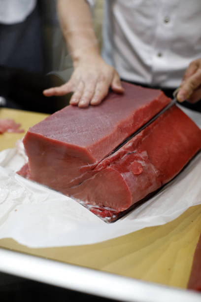 шеф-повар режет ножом корейку красного тунца - tuna tuna steak raw bluefin tuna стоковые фото и изображения