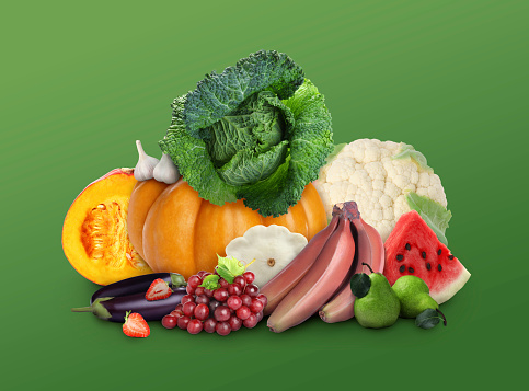 Fresh fruits and vegetables on green background