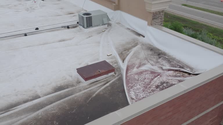 commercial building roof damage covered in white tarp, aerial dynamic