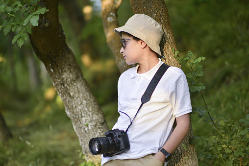 The little photographer takes a walk in the forest and improves himself by taking photos.(eril)