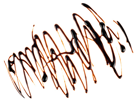 Dark chocolate syrup drizzle isolated on a white background, top view. Splashes of chocolate sauce.