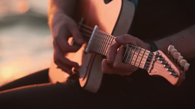 Street musician playing electric guitar hands close up