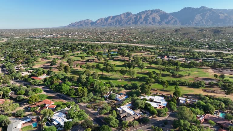 Luxury neighborhood in southwest USA. Aerial shot reveals golf course and mountains in distance.