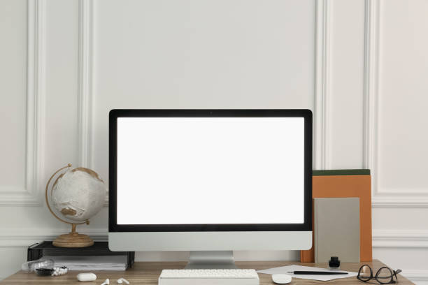 istock Stylish workspace with computer and stationery on wooden desk near white wall 1691134708