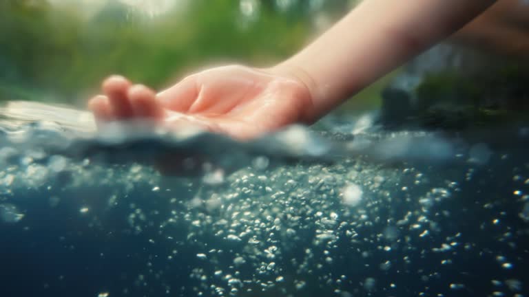 SLO MO Underwater Closeup of Playful Boy's Hand Collecting Bubbles in River Water