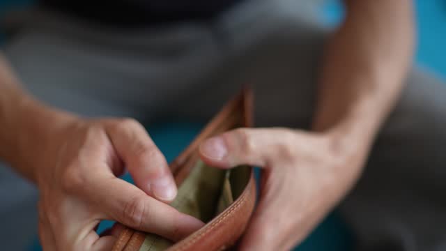 Young man holding wallet and counting money