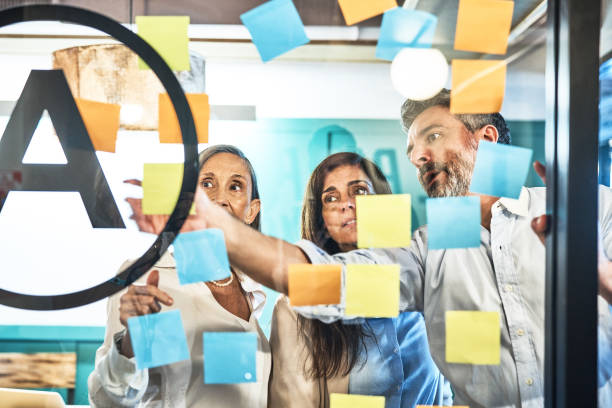istock Businessman explaining business partners over adhesive notes in office 1691189001