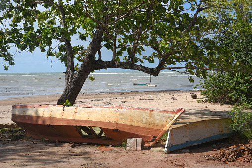 old abandoned fisherman's canoe damaged wooden vessel ocean