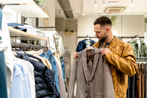 istock Young Man Shops for Clothes in Traditional Store 1691220049