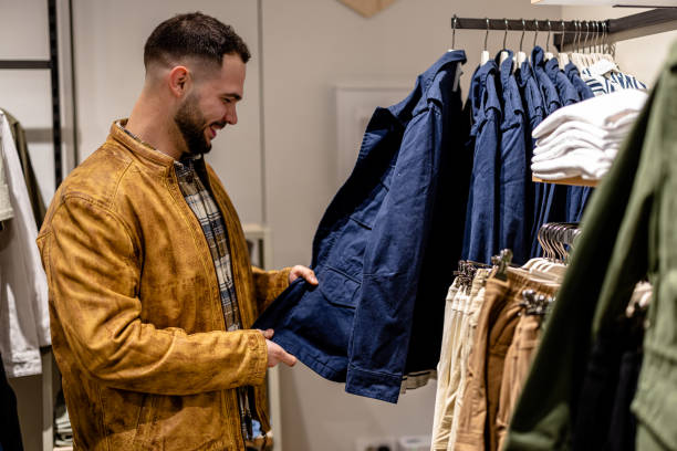 istock Young Man Browsing Clothing Options in Store 1691220587