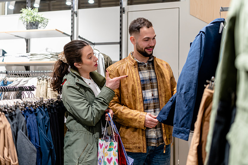 The couple is perusing the store's offerings, admiring the quality and design of the clothes on display