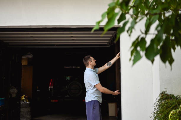 istock Repair At Home.  Man controlling a gate of  garage. 1691232625
