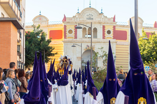 ALMERIA, SPAIN - APRIL 05, 2023 Procession of people in the holy week. Residents participating in the procession wear platforms with images of saints