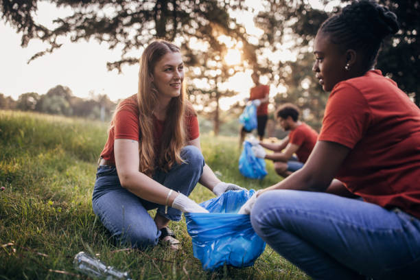 istock Women volunteers cleaning nature 1691359845